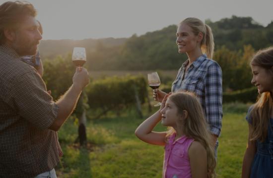 family in vineyard toasting