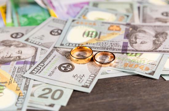 Image of money laying on a table after a divorce with two wedding rings